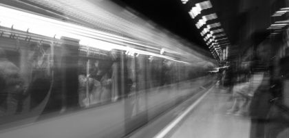 Black and white motion blur of a subway train in an underground station, capturing urban energy.