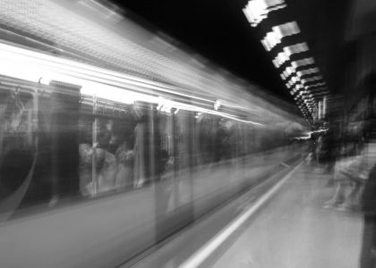Black and white motion blur of a subway train in an underground station, capturing urban energy.